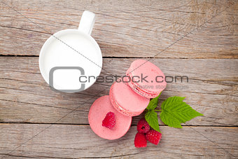 Colorful raspberry macaron cookies and cup of milk