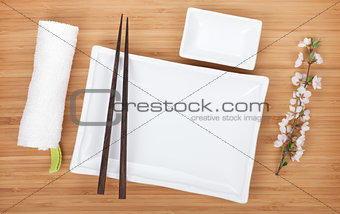 Empty plates, chopsticks and sakura branch