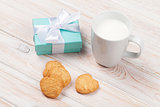 Cup of milk, heart shaped cookies and gift box