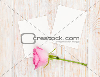 Two blank photo frames and pink rose