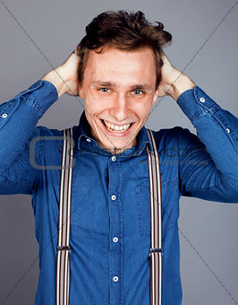young goofy man with pimples pointing in studio