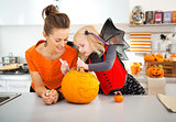 Mother with daughter creating Jack-O-Lantern on Halloween