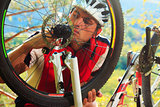 Man cyclist repairing a bike  against blue sky