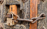 Old styled rusty chain door lock on the wooden door