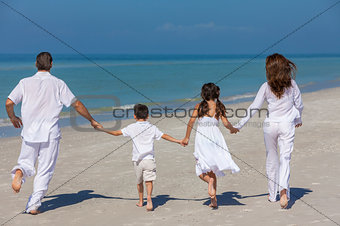 Mother Father and Children Family Running on Beach