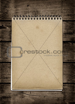 Closed spiral Note book on a dark wood table