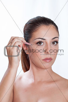 Redhead girl with a makeup brush near her eye