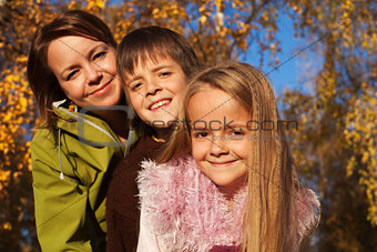 Autumn family portrait in the sunny forest