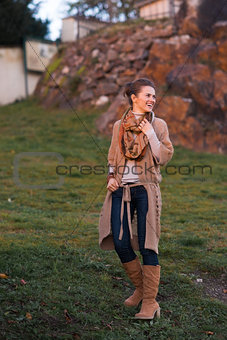 Laughing urban elegant woman walking in evening autumn park