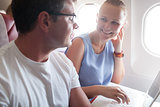 Happy young and woman with laptop in plane