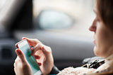 Woman uses smartphone in the car