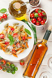 Colorful penne pasta and white wine
