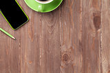 Office wooden desk with smartphone and coffee