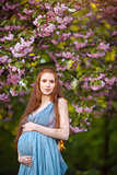 Young  pregnant woman relaxing and enjoying life in nature