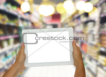 hand holding tablet in supermarket