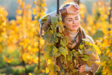 Relaxed woman winegrower standing in vineyard outdoors in autumn