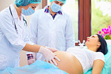 doctor palpates the abdomen of pregnant woman during childbirth
