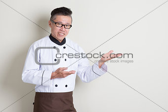 Mature Asian Chinese chef showing something