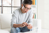 Mature 50s Asian Chinese man eating medicine