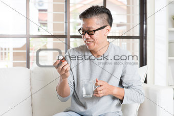Asian man eating vitamins