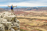 hiker on rocky cliff overlooking valley