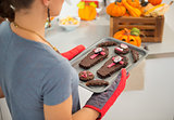 Closeup on tray with Halloween biscuits in hands of housewife