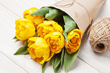 Yellow tulips over wooden table