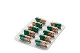 Green pills in a blister pack on white background