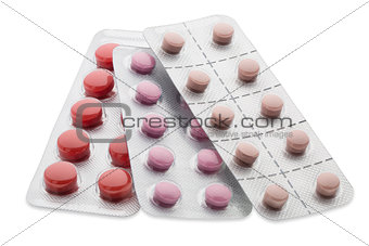 Set of colorful pills in a blister pack on white background