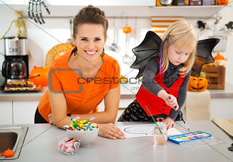 Mother with girl in halloween costume drawing Jack-O-Lantern