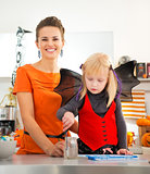 Girl in halloween bat costume spending time with mother
