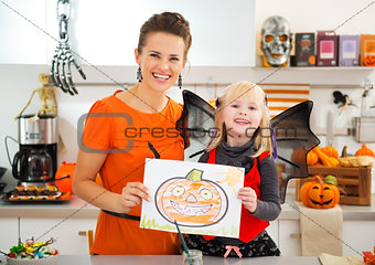 Girl with mother showing halloween Jack-O-Lantern drawing