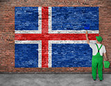 House painter paints flag of Iceland on old brick wall