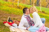 young couple in love kissing on a picnic on a blanket
