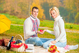 man and woman hold in their hands a red apple