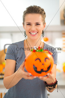 Woman holding halloween bucket full of trick or treat candy