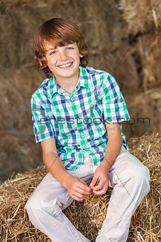 Young Happy Boy Sitting Smiling on Hay Bales