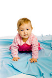 baby girl crawling on the blue coverlet. Studio