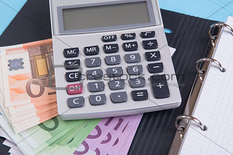 money, calculator and notebook