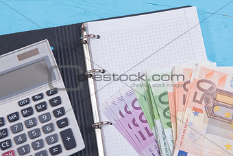 money, calculator and notebook