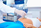doctor conducting the ultrasound procedure to pregnant woman