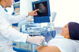doctor conducting the ultrasound procedure to pregnant woman