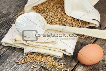Pita bread with grains,egg and flour on old wooden table