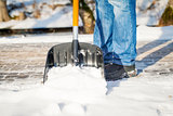 Man with a snow shovel on the sidewalk