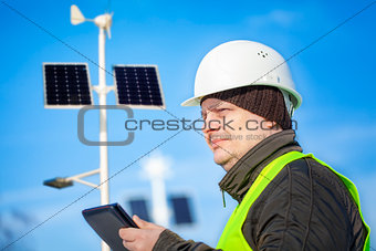 Electrical Engineer with tablet PC near street lighting