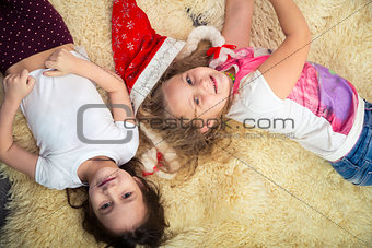 two girls on the floor, playing at home, top view