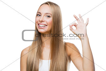 Young woman shows gesture ok on white background