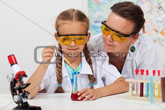 Teacher overseeing chemical experiment in science class