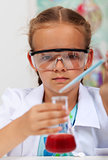 Young girl in elementary science class with chemical recipient a