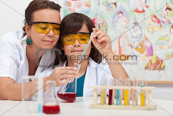 Young boy in elementary science class doing chemical experiment